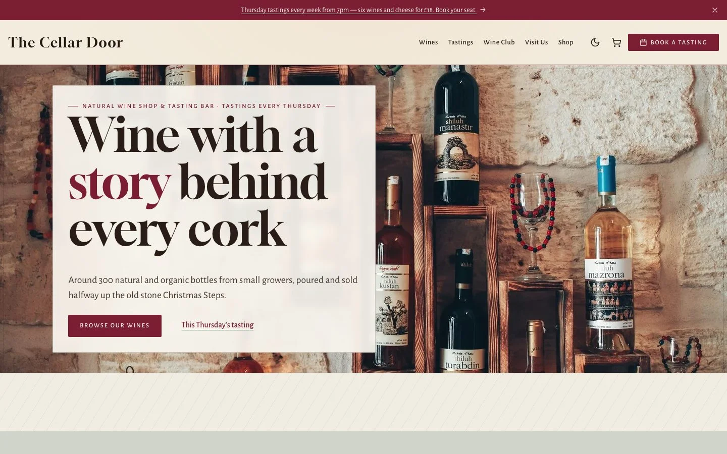 Accueil du site The Cellar Door : bouteilles de vin contre un mur de pierre, sous le titre et les boutons de la cave